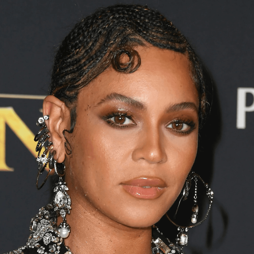 Beyoncé with elegant ear climbers, huggies, and multiple gold earrings