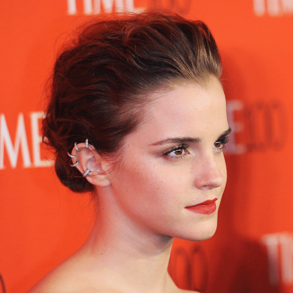 Emma Watson wearing minimalist lobe and helix piercings with tiny gold studs