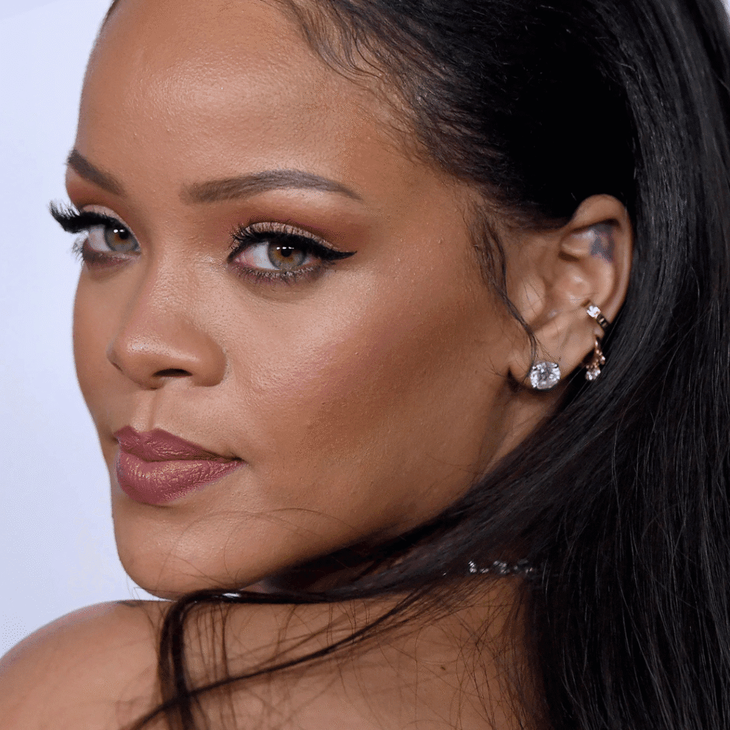 Rihanna wearing bold cartilage and lobe piercings with large hoops and cuffs