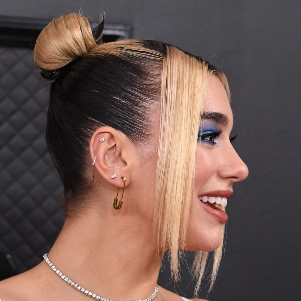 Dua Lipa ear piercings with multiple lobe hoops and studs