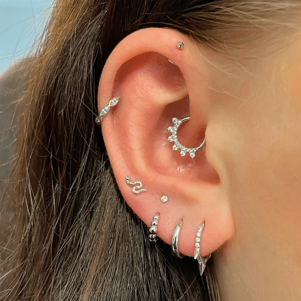 Minimal ear piercing stack featuring helix and flat piercings in yellow gold