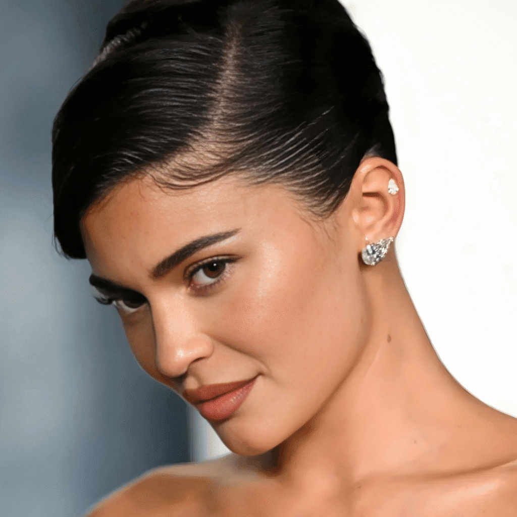 Kylie Jenner with double and triple lobe piercings wearing tiny gold hoops and studs