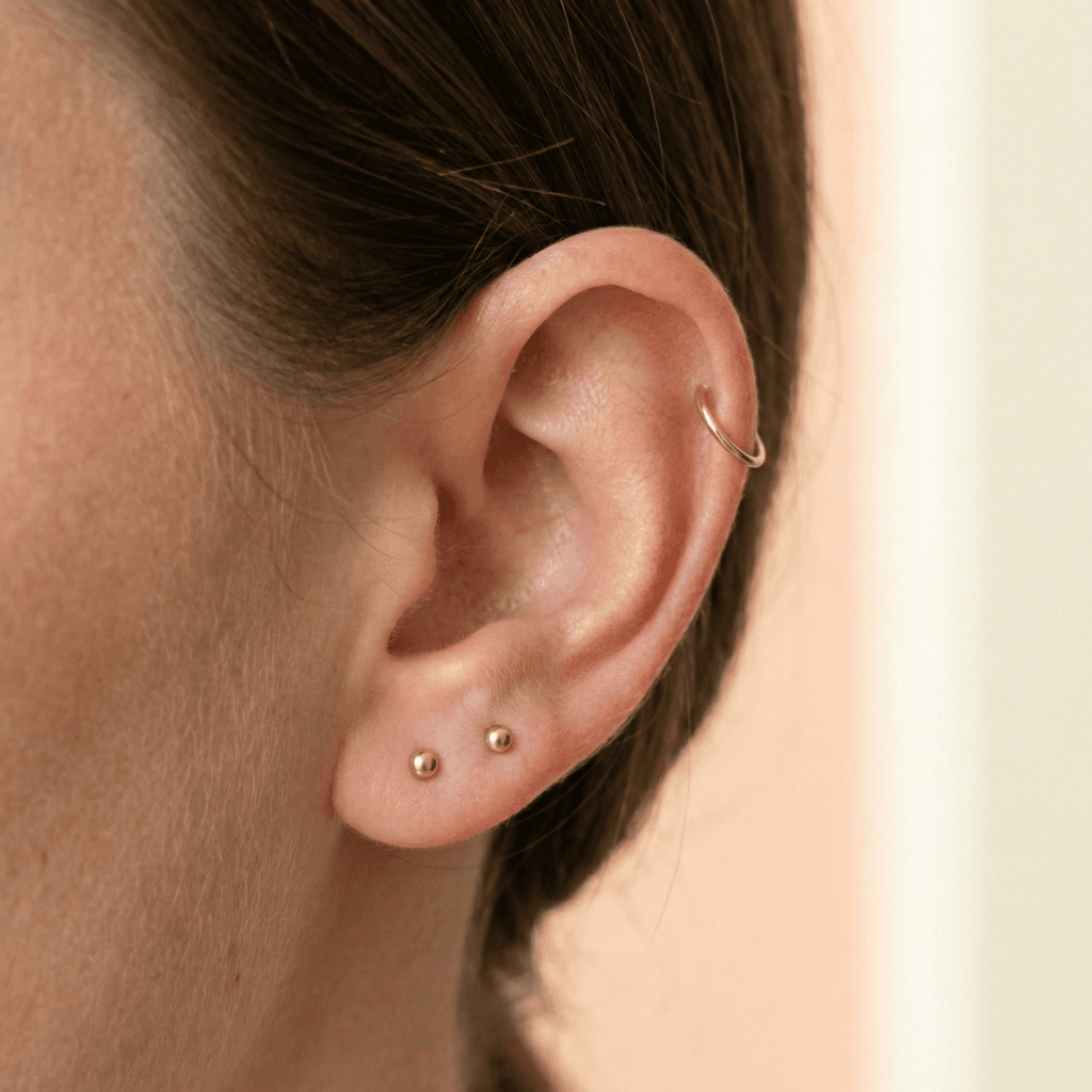 Beginner curated ear with two lobe studs and single helix hoop