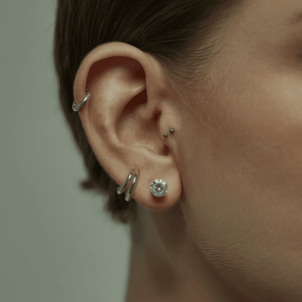 Curated ear featuring statement conch hoop with supporting lobe and forward helix piercings