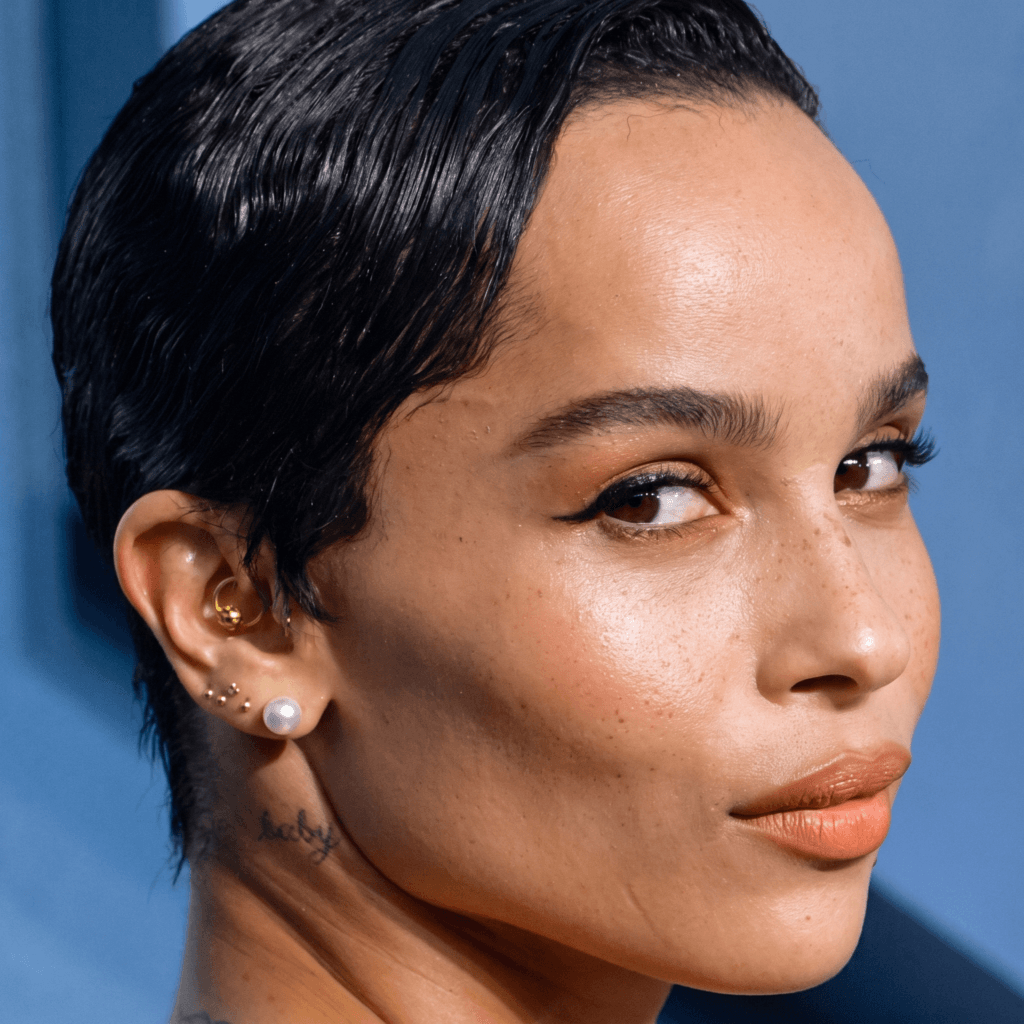 Diamond lobe stud and subtle gold cartilage piercings in a curated ear look inspired by Zoë Kravitz