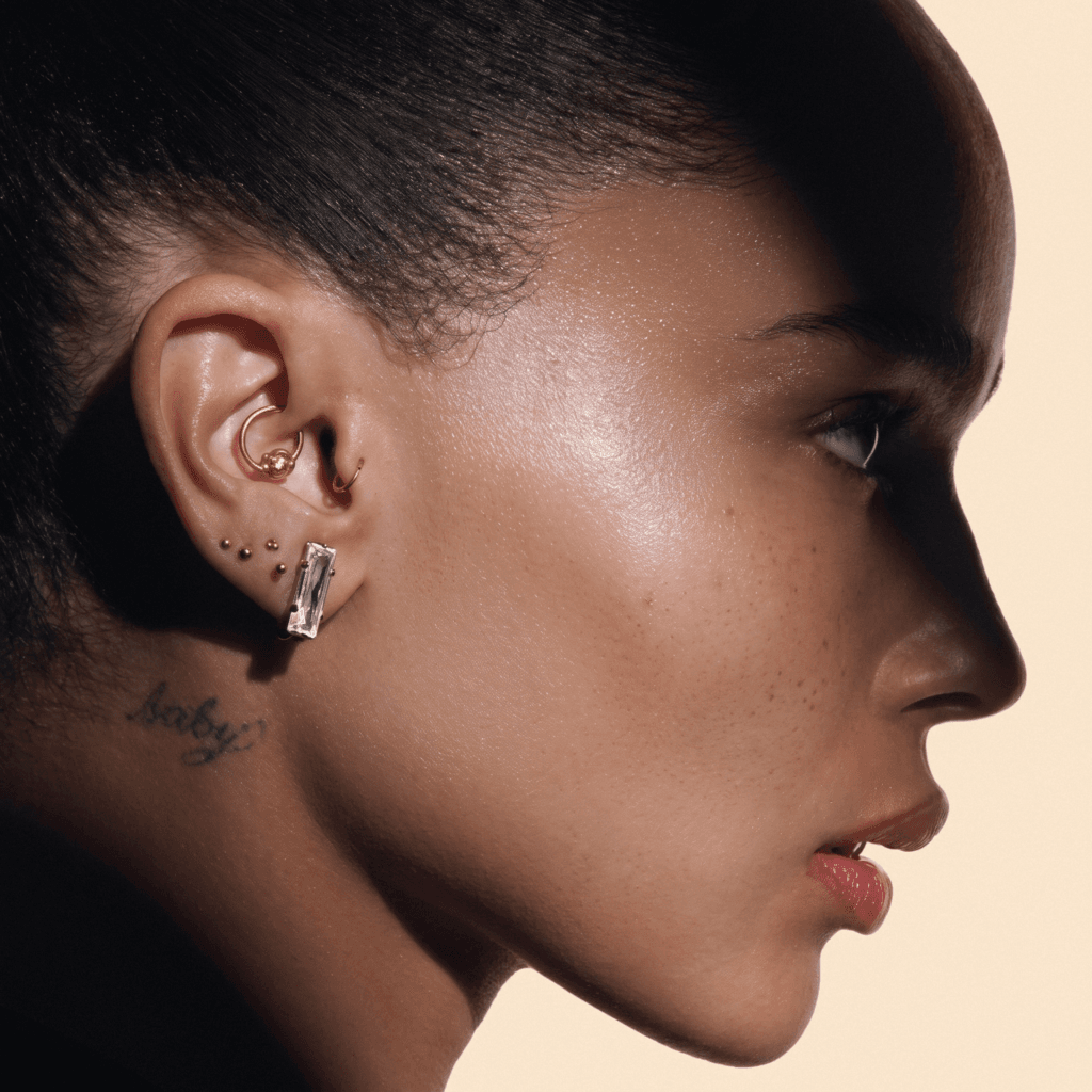 Zoë Kravitz inspired minimal ear piercing stack with delicate studs across the lobe and cartilage